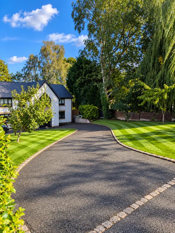 Striped front lawns either side of a curved driveway